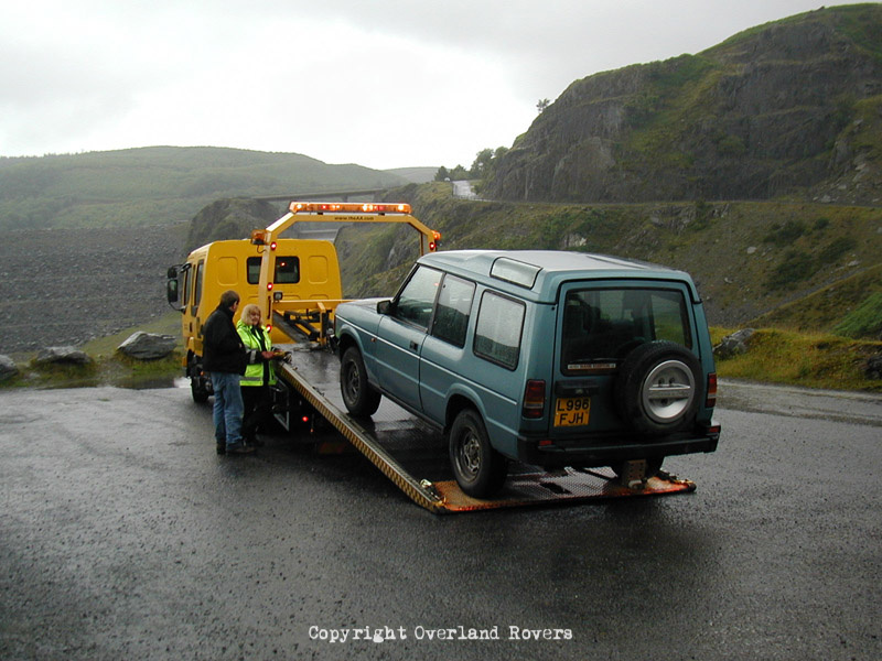 A 3 door Land Rover DIscovery 200 Tdi being winched onto the back of an AA recovery truck