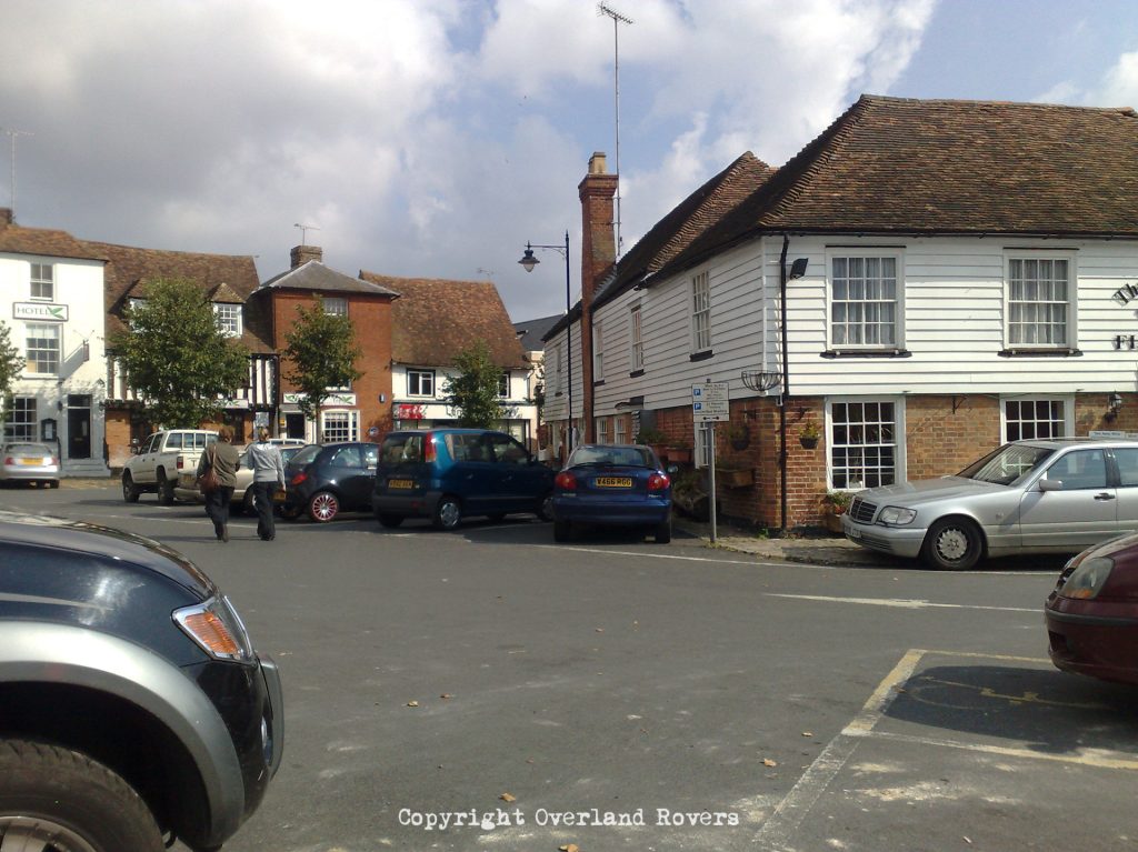 View across a car park to some older style buildings with wooden fascias, set in Lenham Kent.